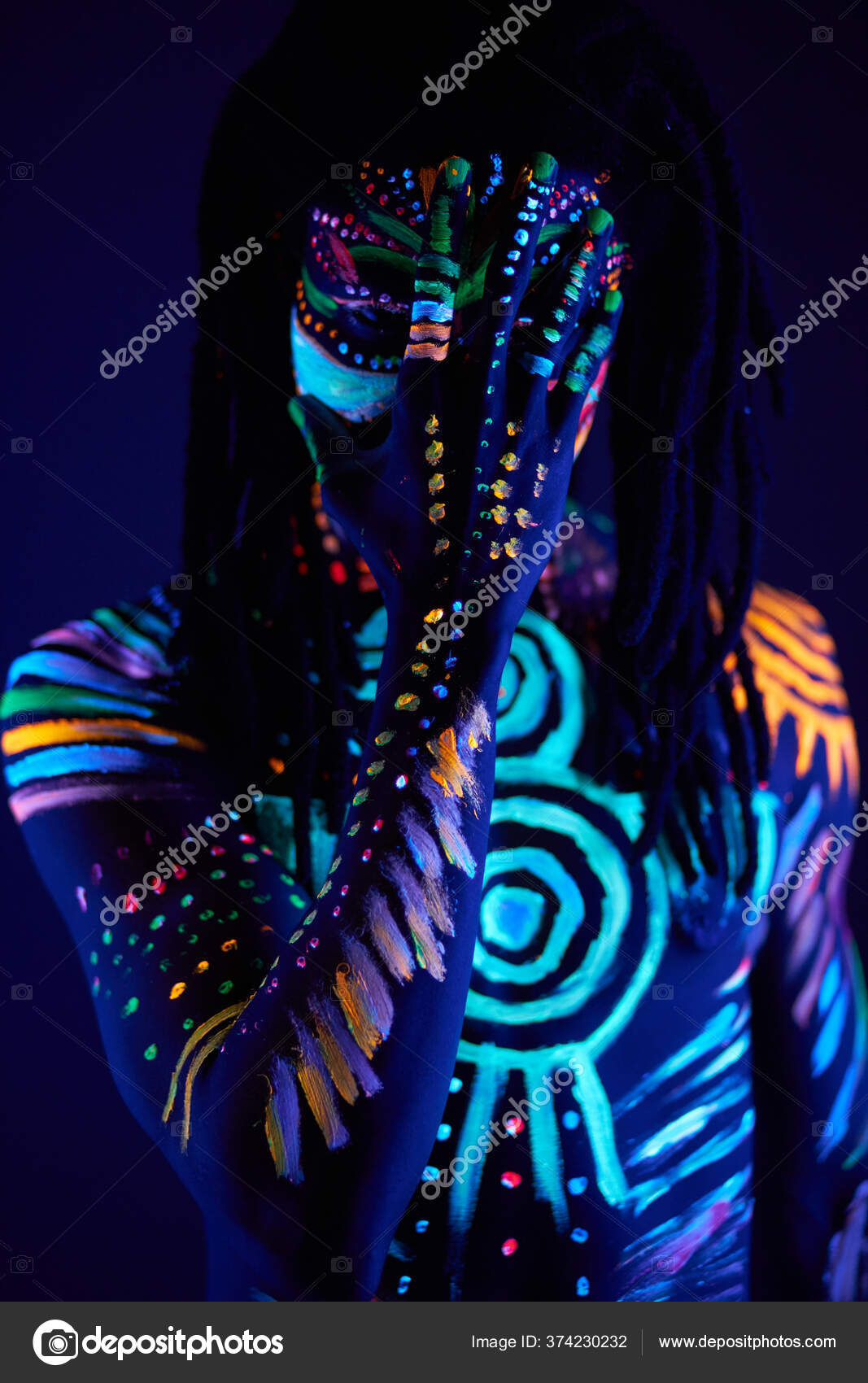 Handsome guy with UV body art close his face Stock Photo by